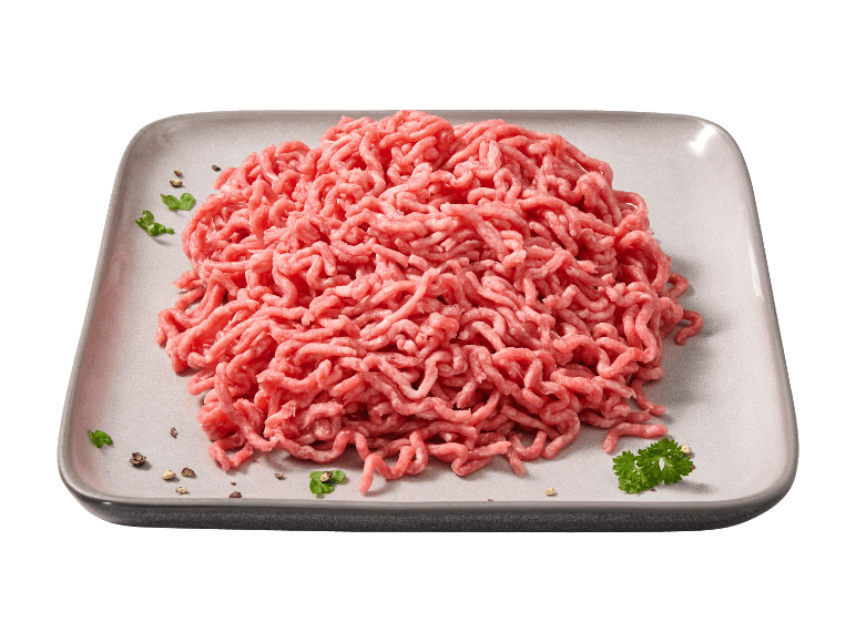 Frisches Hackfleisch auf einem grauen Teller mit Petersilie und Pfeffer.