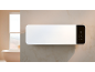 Weißer Wandheizer mit Digitalanzeige in einem modernen Badezimmer mit Badewanne.