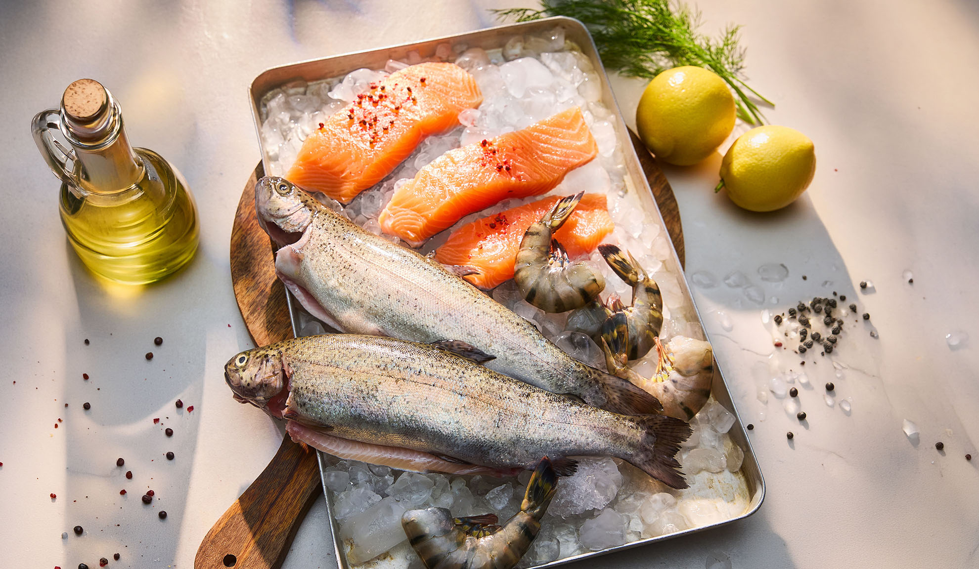 Frischer Fisch, Lachsfilets und Garnelen auf Eis, mit Zitronen und Öl.