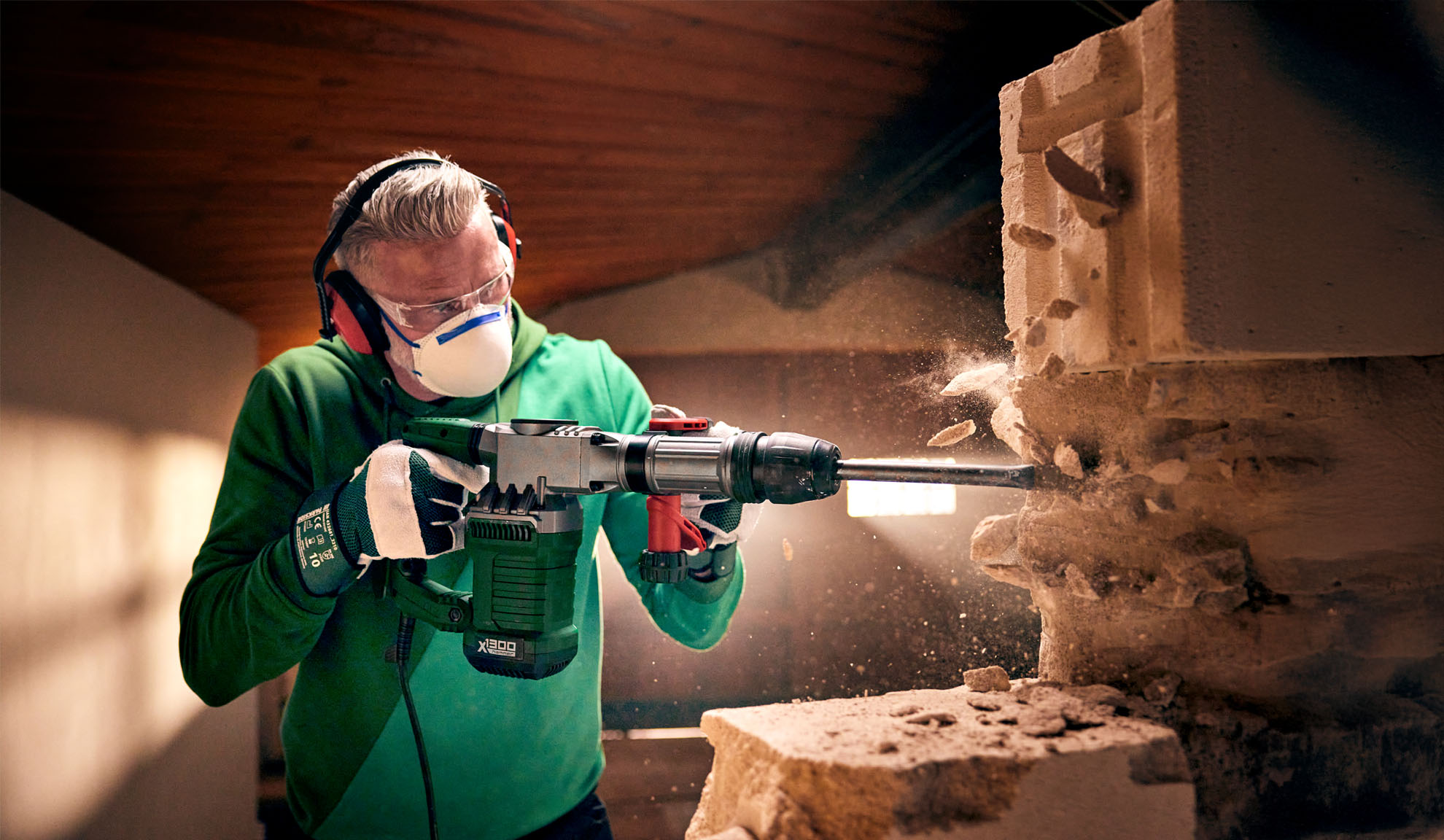 Ein Mann verwendet einen Worx X-BRUSHLESS Abbruchhammer, um einen Betonblock zu zerbrechen.