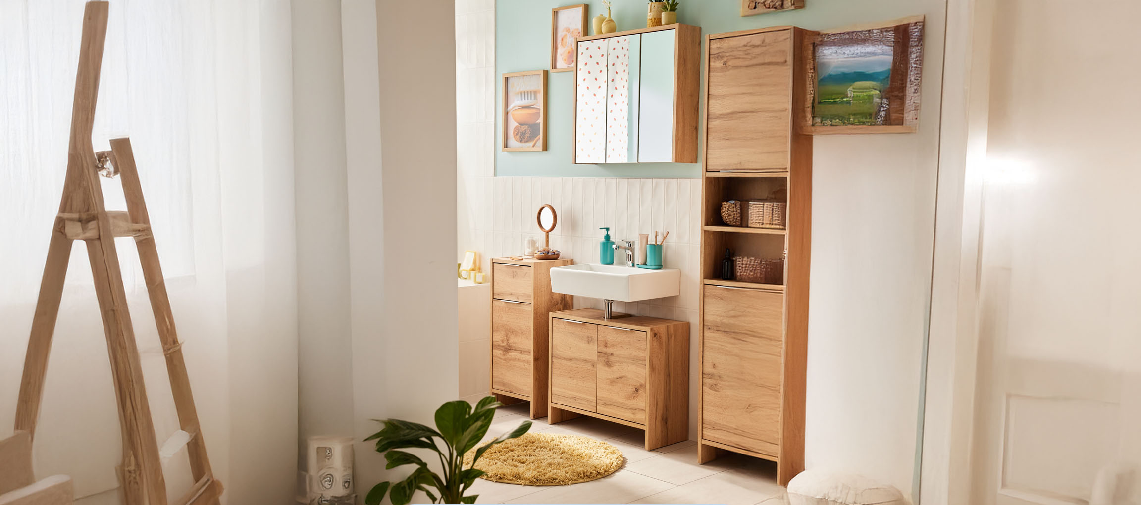 Modernes Badezimmer mit hellen Holzmöbeln, weißem Waschbecken und Spiegel.