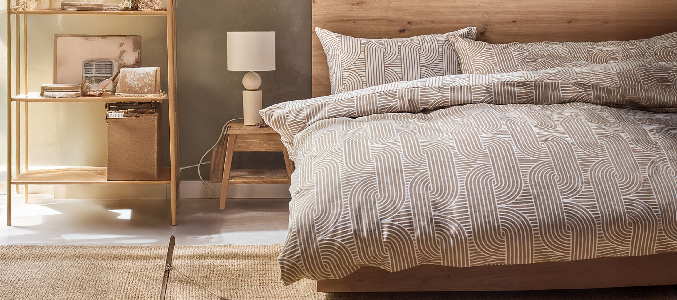 Schlafzimmer mit Holzbett, gemusterter Bettwäsche, Nachttisch und Regal.