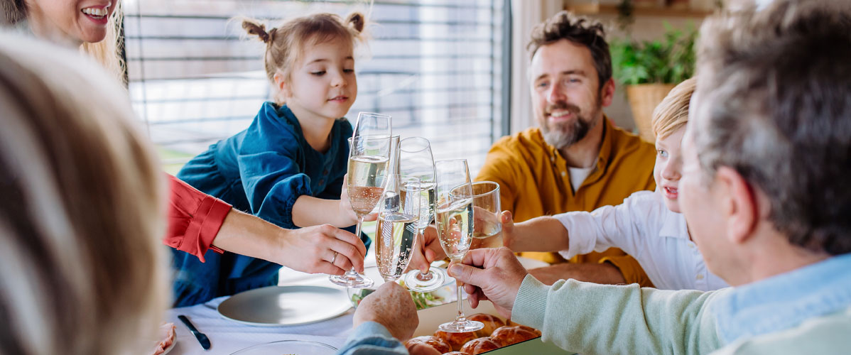 Familie stößt am Esstisch gemeinsam an