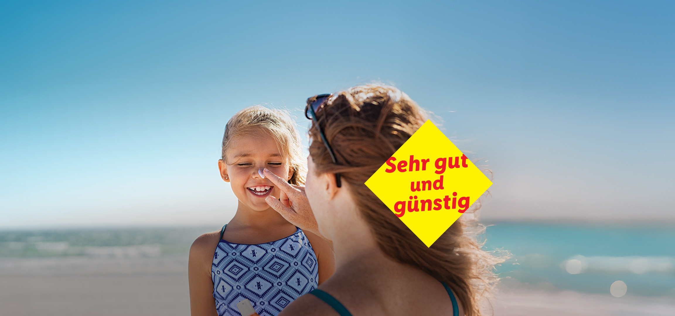 Eine Mutter schmiert ihrer Tochter Sonnencreme auf.  Sehr gut und günstig.