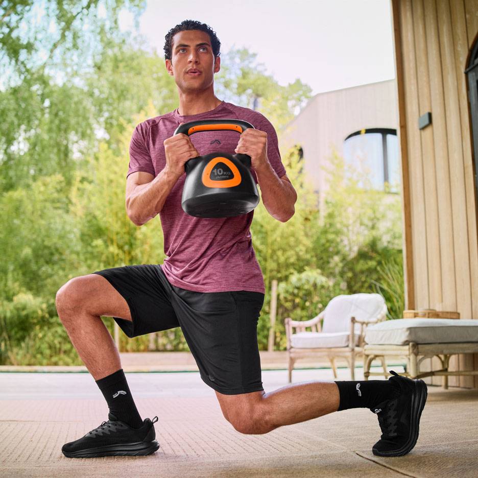 Mann macht Ausfallschritte mit einer 10 kg Kettlebell im Freien.