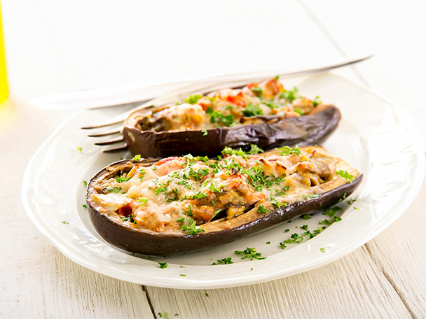 Gefüllte Auberginen mit Käse und Kräutern auf einem weißen Teller.