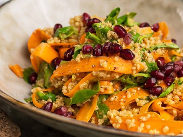 Ein gesunder Quinoa-Salat mit Karotten, Granatapfelkernen und Kräutern.