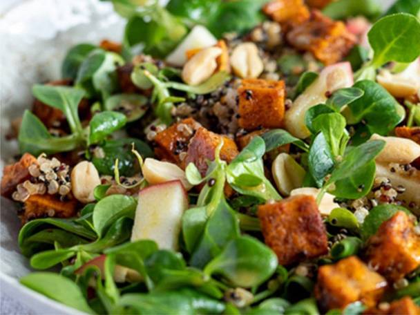 Ein gesunder Quinoa-Salat mit geröstetem Süßkartoffel, knackigem Feldsalat und Erdnüssen.