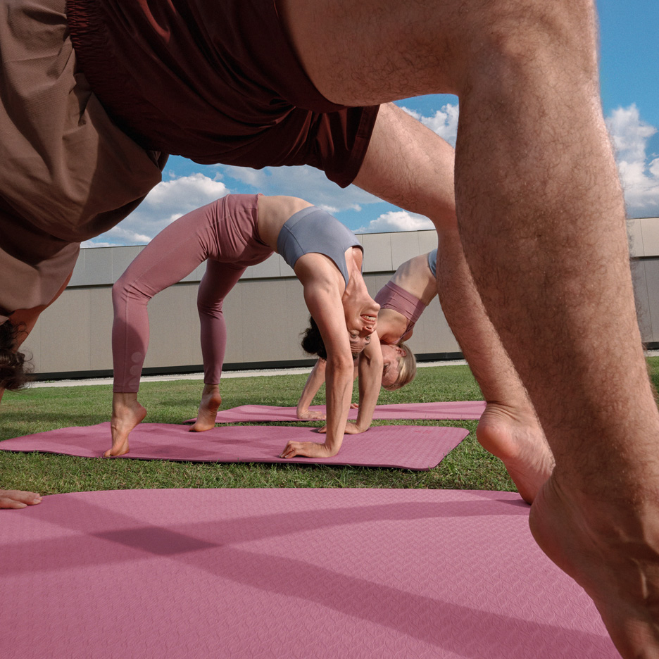 Menschen machen Yoga im Freien auf Yogamatten, in Sportkleidung.