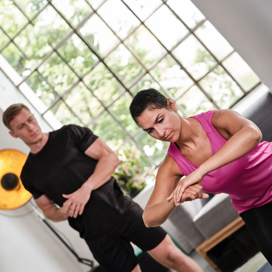 Frau trainiert mit einem Personal Trainer.