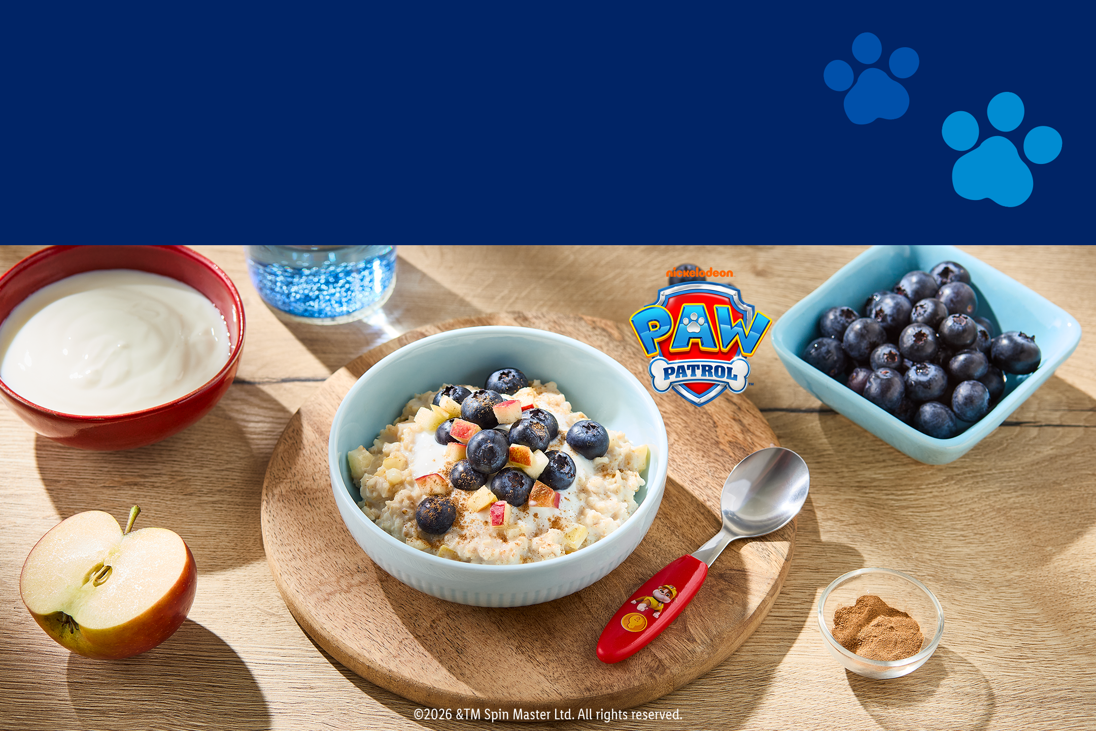 Schüssel Haferbrei mit Blaubeeren und Äpfeln, Joghurt und Zimt, mit Paw Patrol Logo.