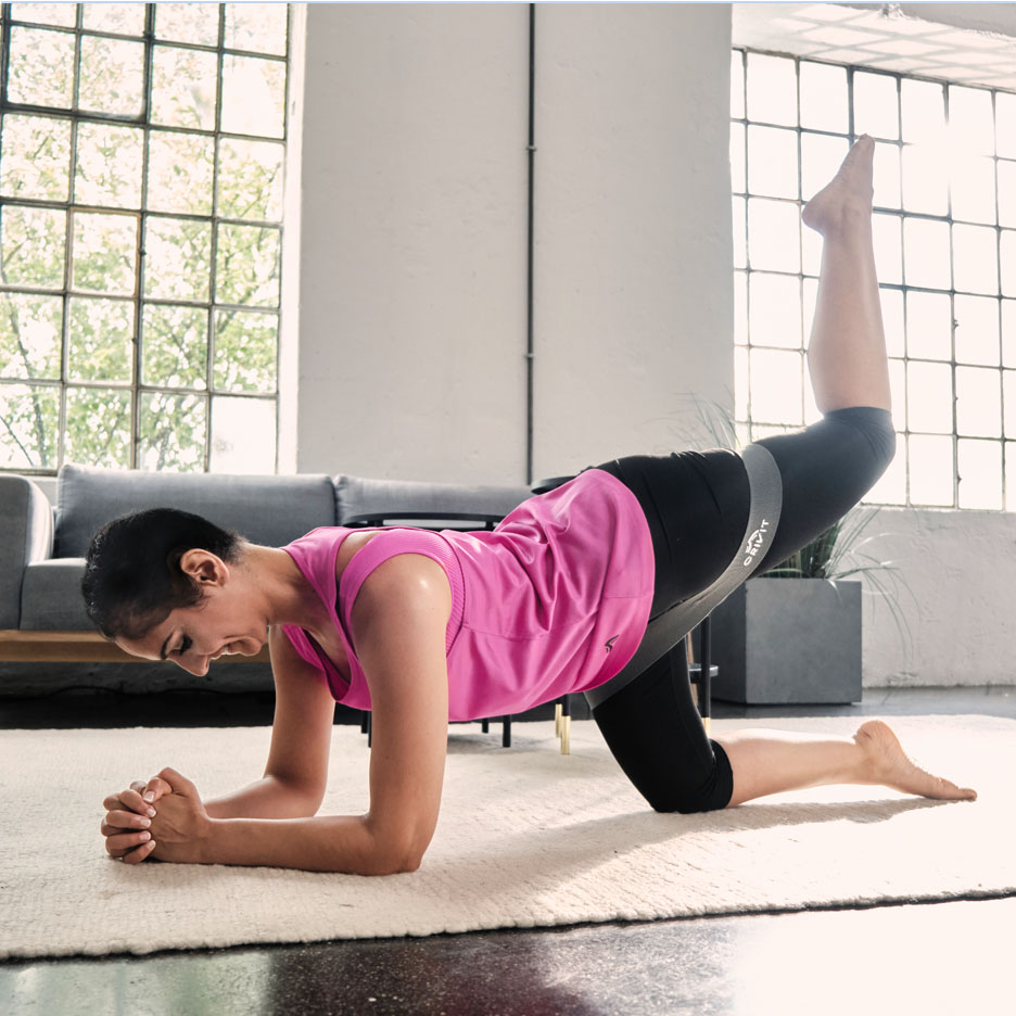 Frau macht Beinübungen mit Senfit Resistance Band.