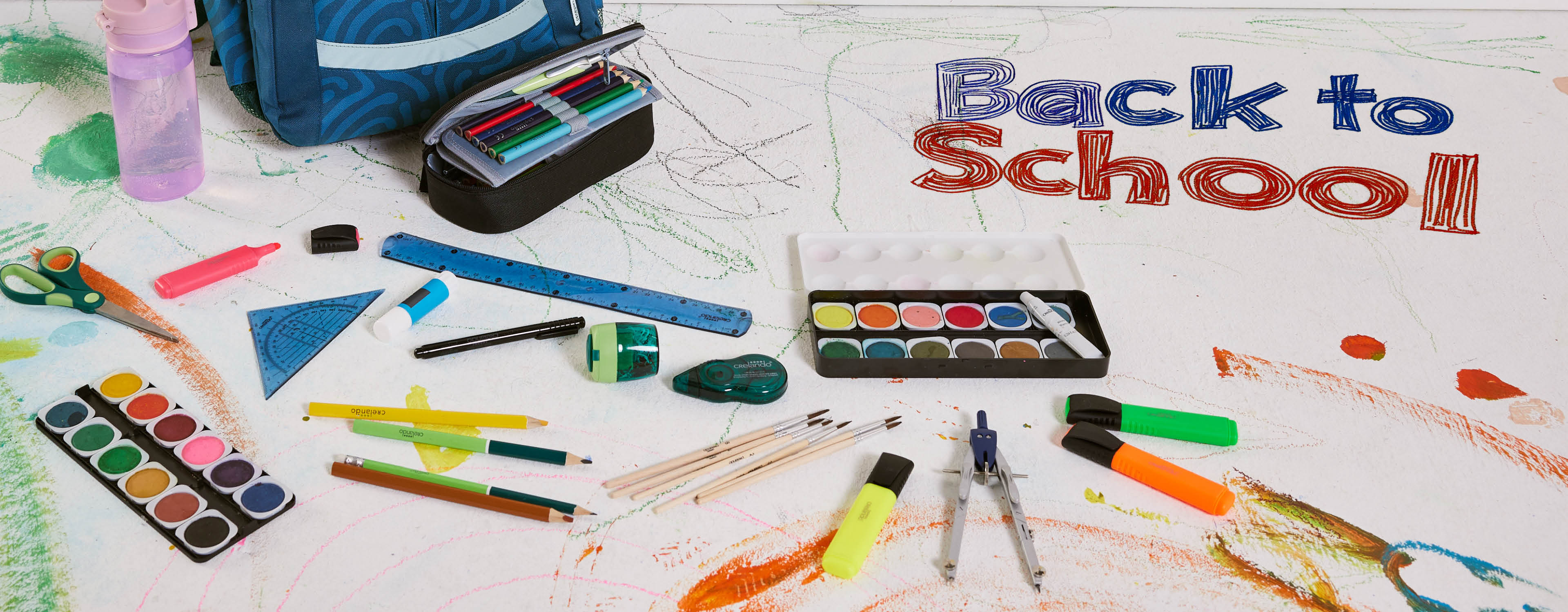 Schultasche, Stifte, Malkasten und Zeichenutensilien liegen auf einem mit Kinderzeichnungen verzierten Boden; 'Back to School' steht geschrieben.