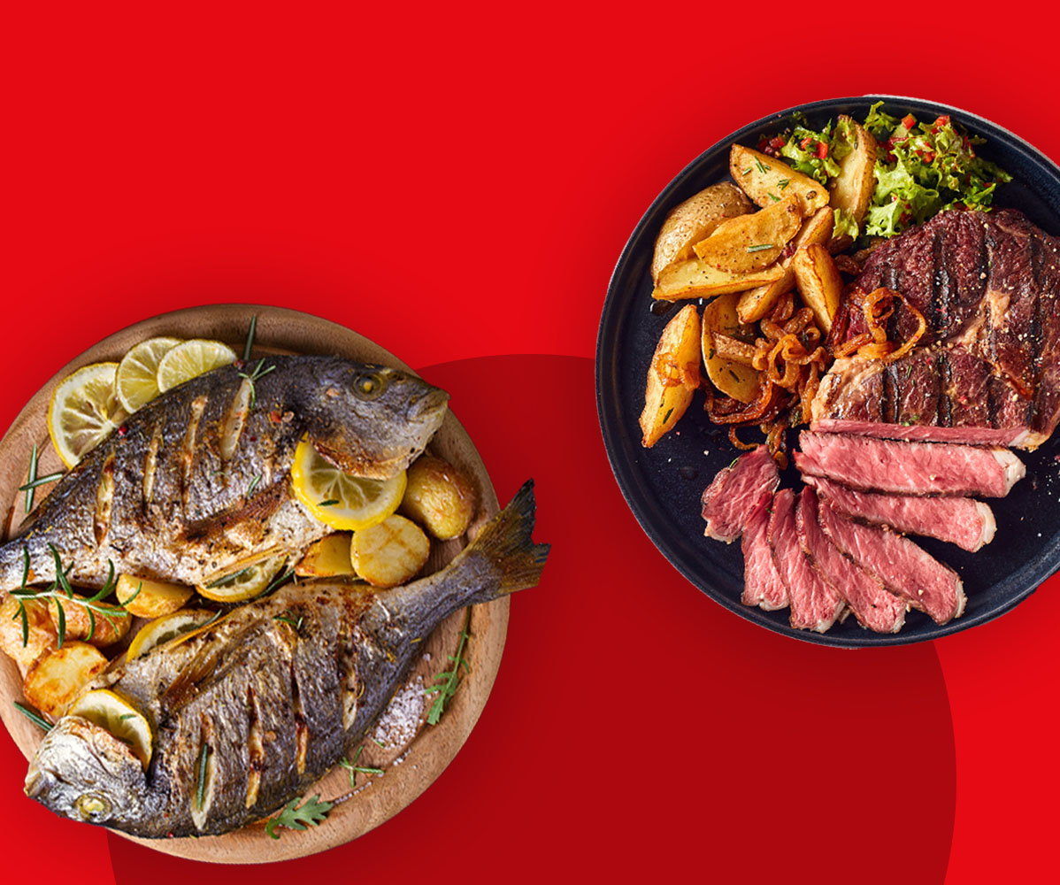 Gegrillter Fisch und Steak mit Kartoffeln und Salat auf roten Hintergrund.