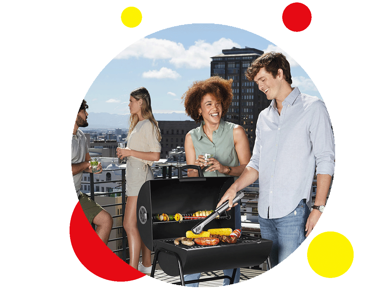 Freunde grillen auf einer Dachterrasse mit einem schwarzen Kugelgrill.