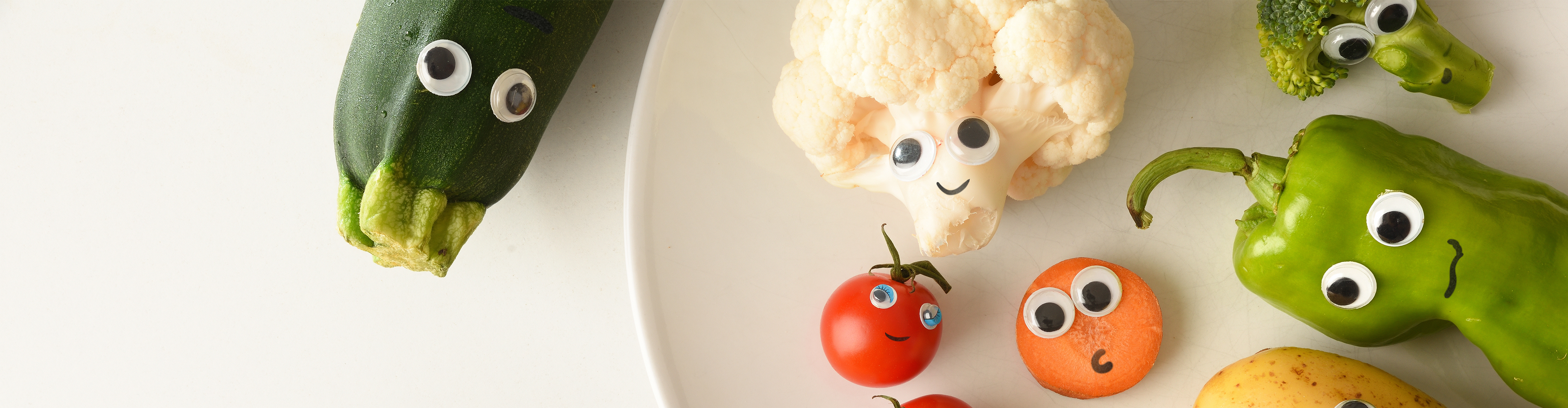 Lustiges Gemüse mit Wackelaugen: Zucchini, Blumenkohl, Tomaten, Karotten, Paprika und Brokkoli.