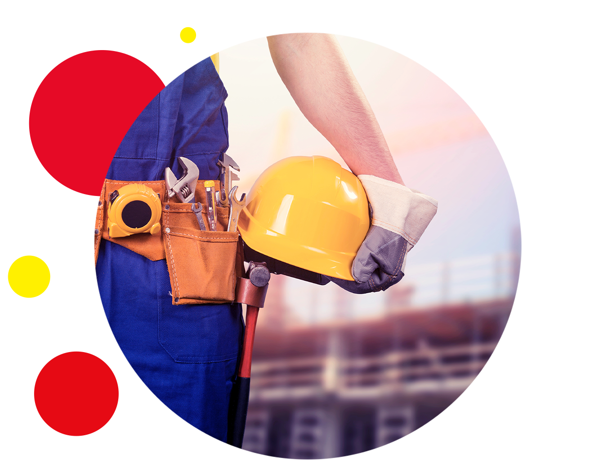 Bauarbeiter mit Werkzeuggürtel, Schutzhelm und Handschuhen auf einer Baustelle.