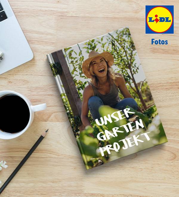 LIDL Fotos: Ein Buch mit dem Titel 'Unser Garten Projekt' liegt auf einem Holztisch neben einem Laptop und einer Tasse Kaffee.