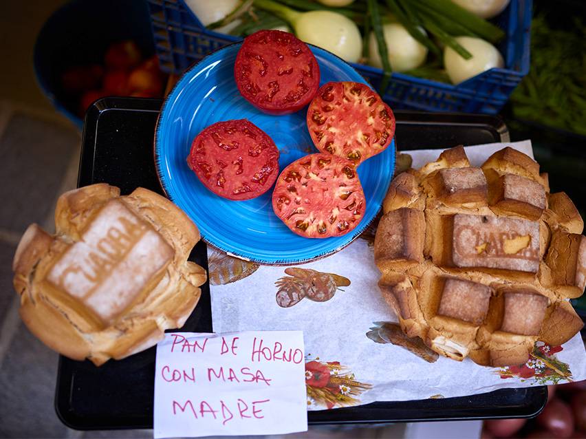 Frische Tomaten und hausgemachtes Sauerteigbrot auf einem Markt.