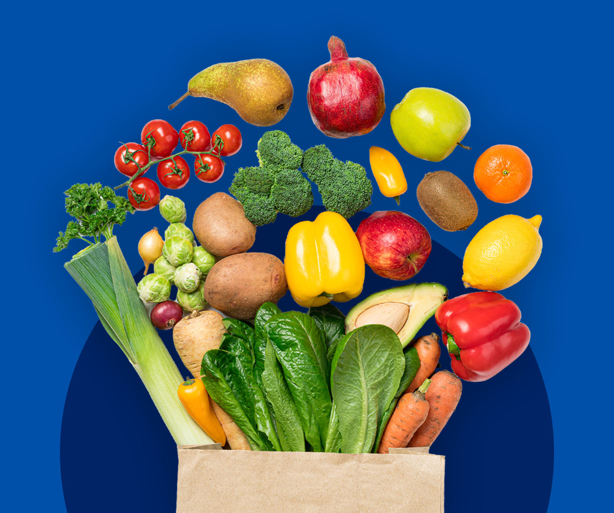 Ein brauner Papierbeutel voller frischem Obst und Gemüse schwebt vor einem blauen Hintergrund.