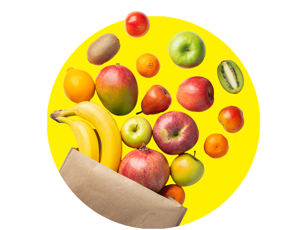 Früchte wie Bananen, Äpfel, Mangos und Kiwis fallen in eine Papiertüte.