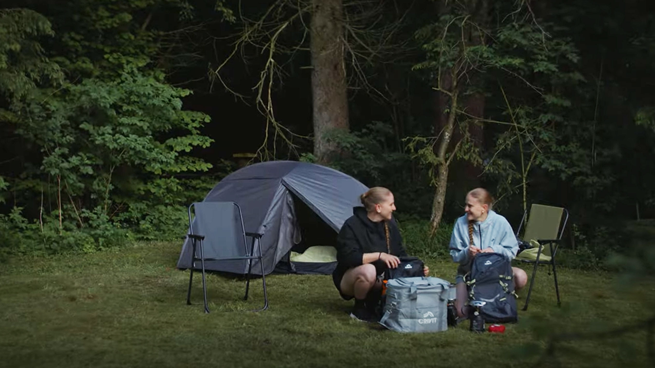 Zwei Frauen campen mit einem Crivit Zelt und Klappstühlen.