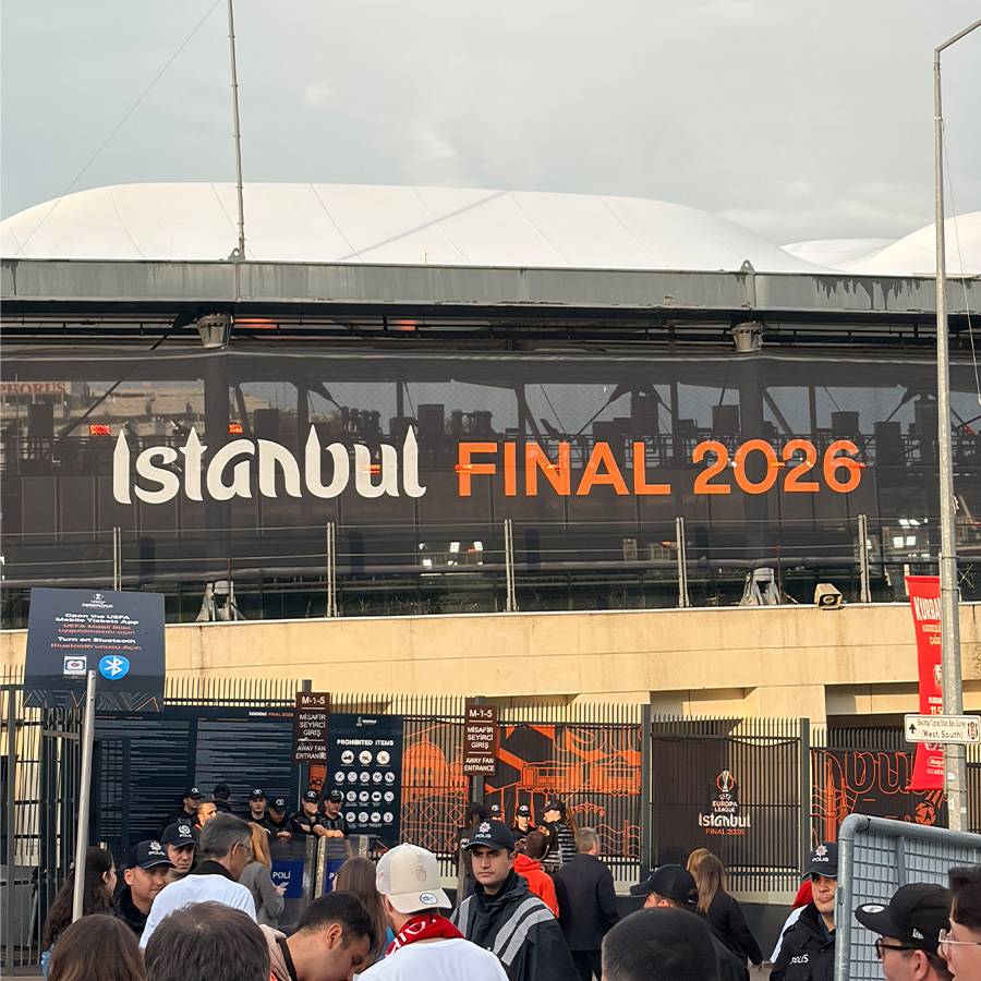 Ein Stadion mit einem großen Banner, das „Istanbul FINAL 2026“ zeigt, und Menschen davor.