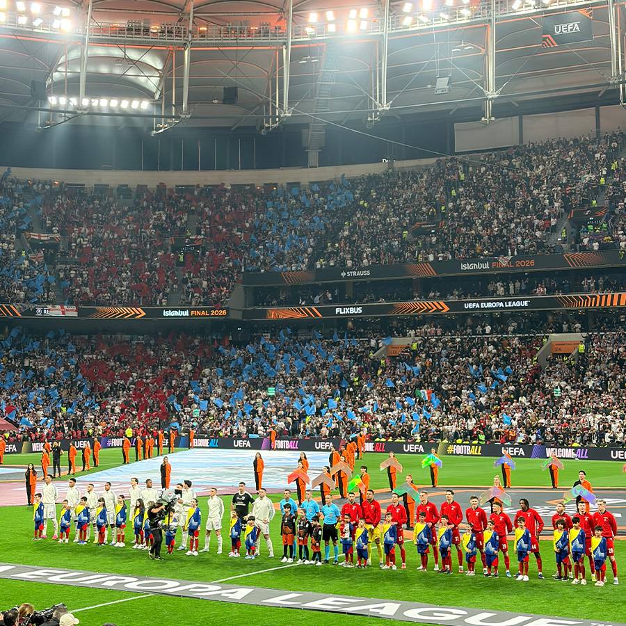Fußballstadion mit Spielern, Kindern und Zuschauern, Schriftzug „Istanbul FINAL 2026“.