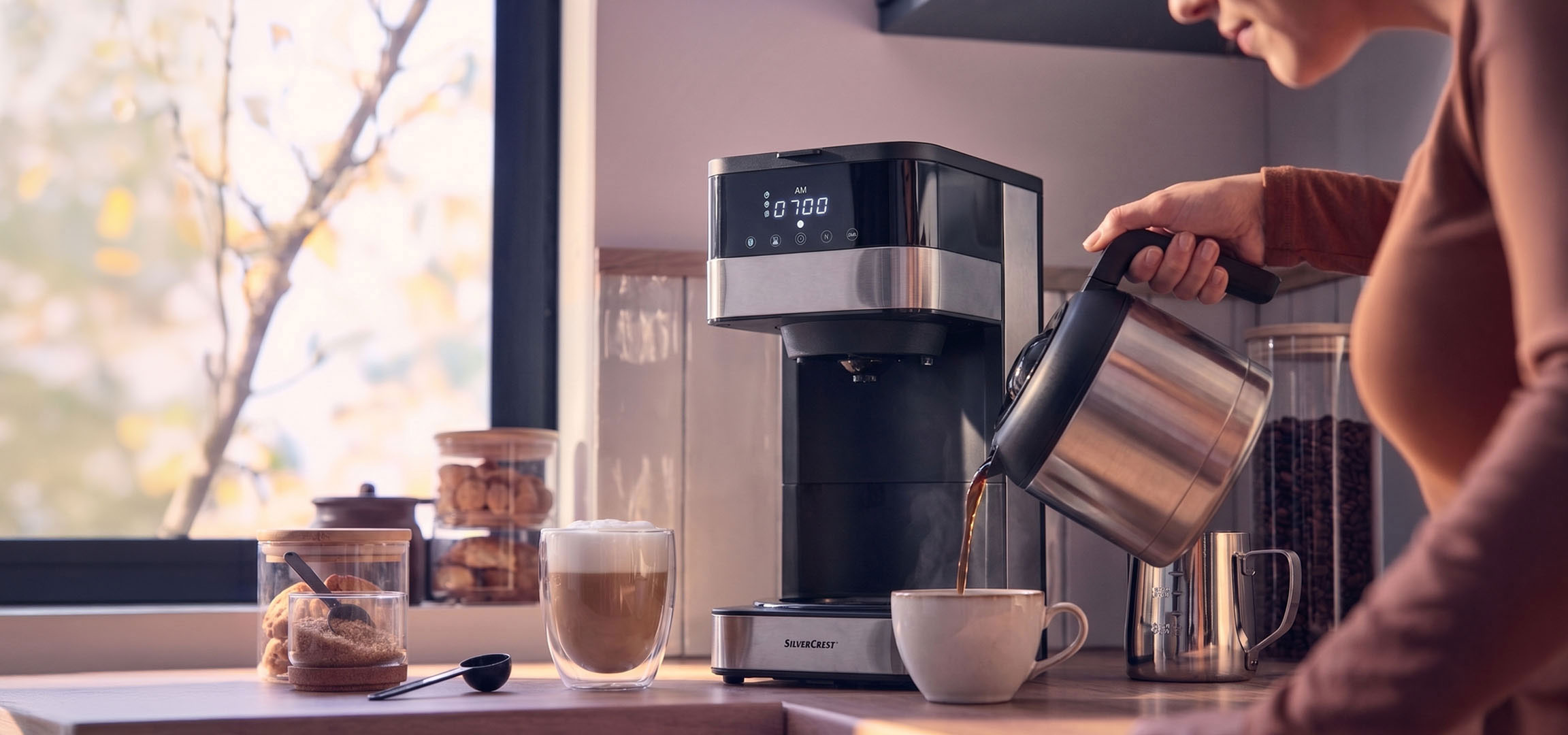 KI-generiert: Kaffeemaschine gießt Kaffee in eine Tasse, mit hellem Fenster im Hintergrund.
