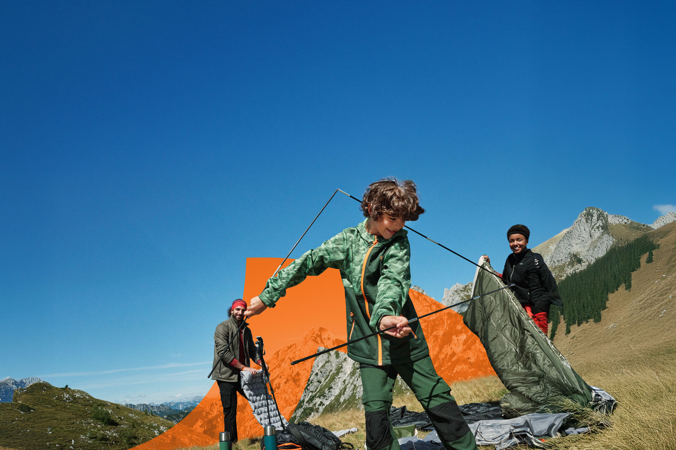 Familie baut Zelt in den Bergen auf, mit Campingausrüstung und Outdoor-Kleidung.