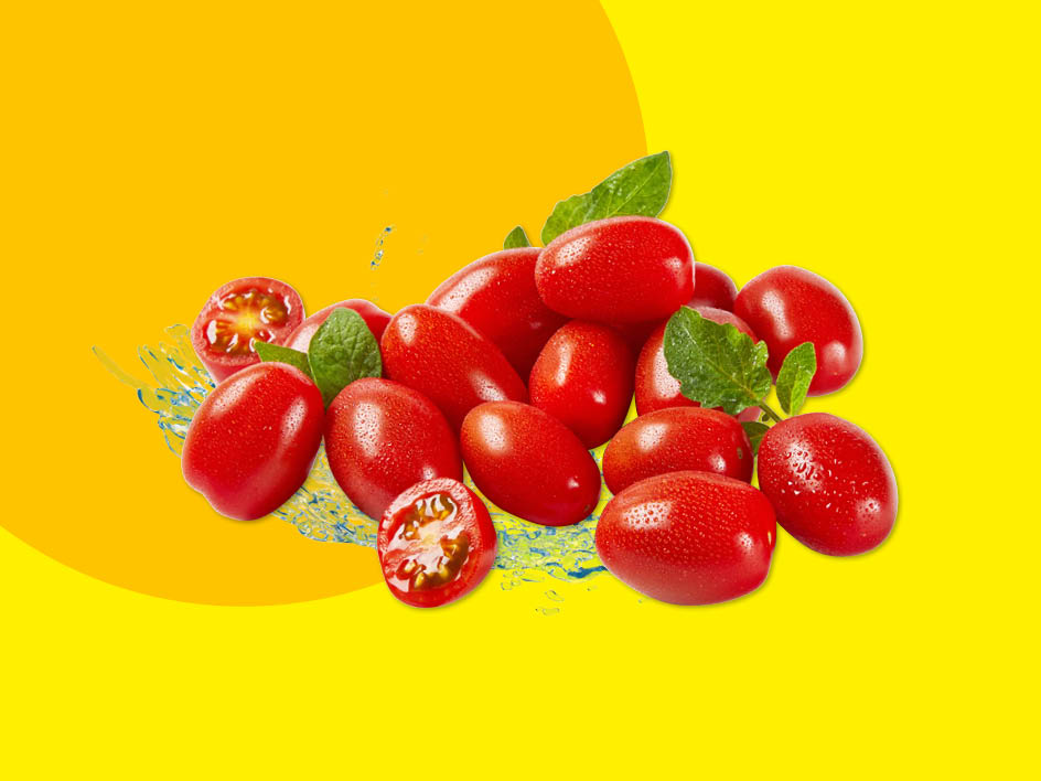 Ein Haufen roter Kirschtomaten mit grünen Blättern und Wasserspritzern auf gelbem Hintergrund.