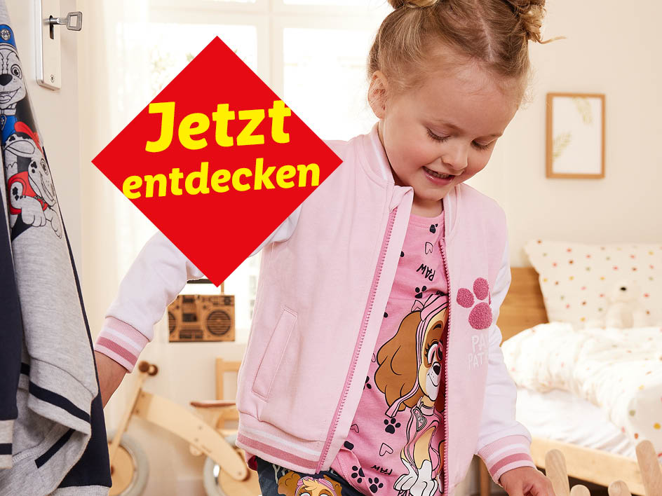 Ein Mädchen in einem Paw Patrol Outfit mit einem roten Werbebanner.