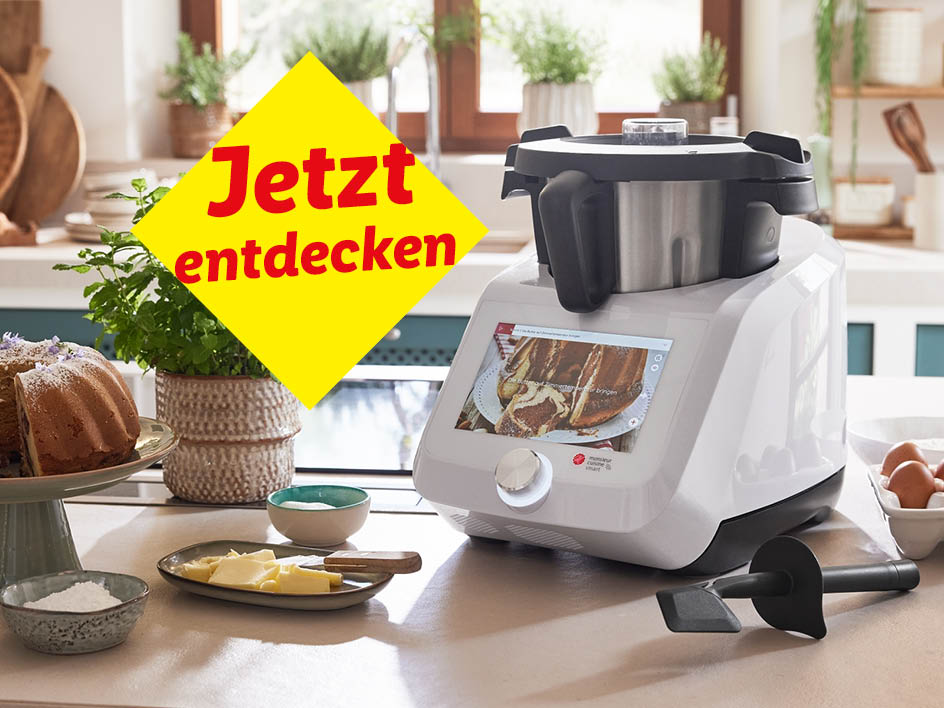 Ein Monsieur Cuisine Connect Küchenmaschine auf einer Küchenarbeitsplatte mit Kuchen und Backzutaten.