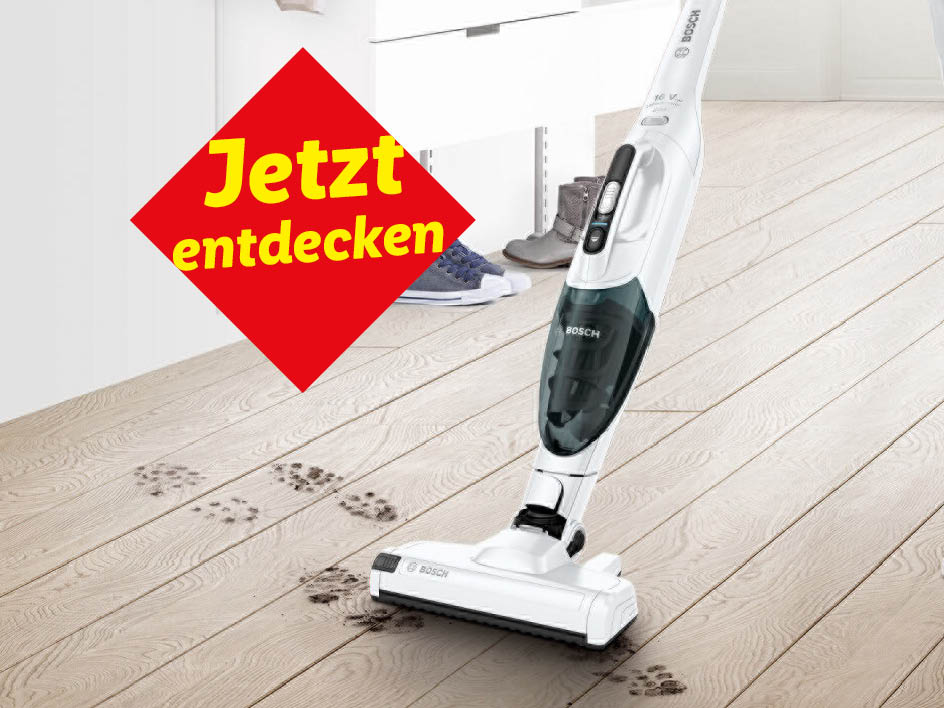 Ein weißer Bosch-Staubsauger reinigt schmutzige Fußabdrücke auf einem Holzboden.