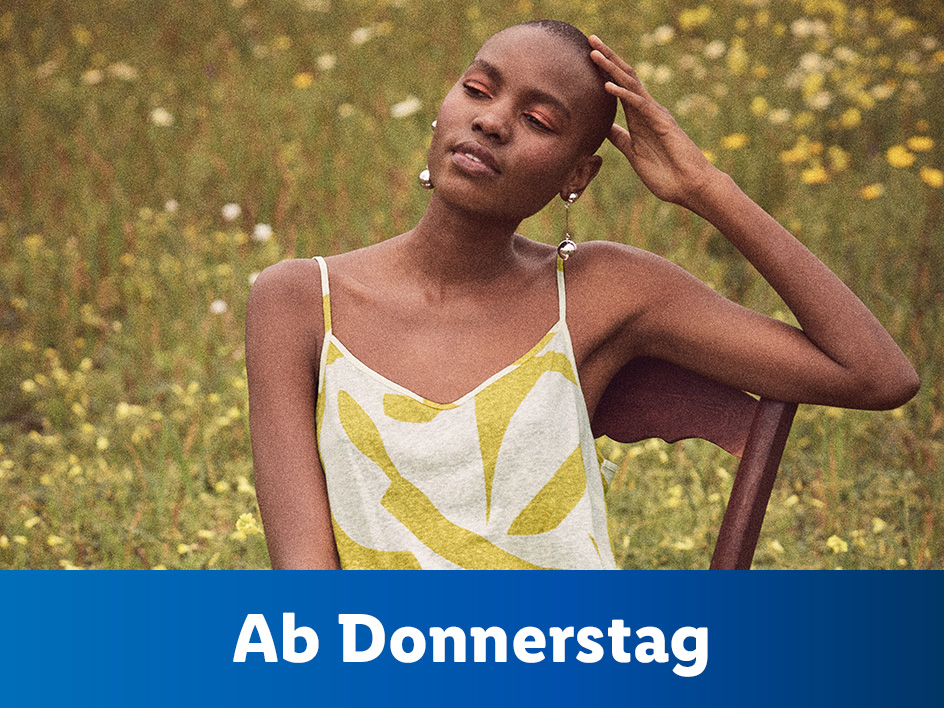 Ab Donnerstag:  Modell trägt ein gelb-weißes Oberteil im Blumenfeld.