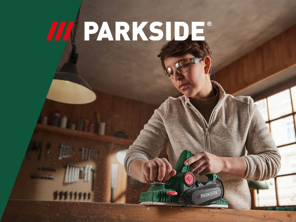 Ein Handwerker verwendet einen Parkside-Hobel zum Bearbeiten von Holz.