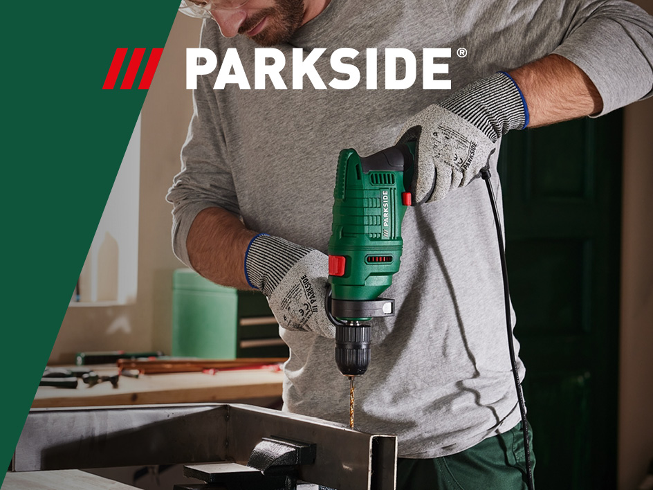 Mann bohrt mit einer grünen Parkside Bohrmaschine in Metall.
