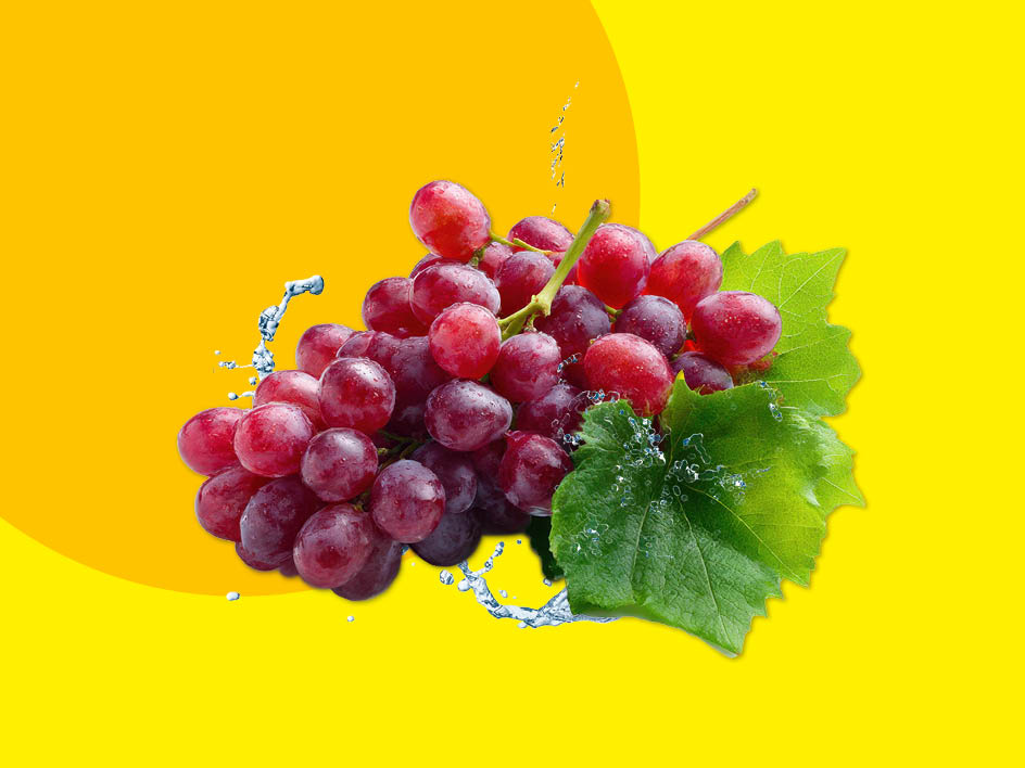 Eine Traube roter Weintrauben mit Wasser, das darüber spritzt, auf gelbem Hintergrund.