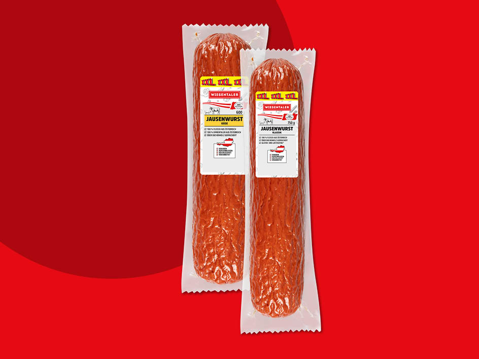 Zwei Wiesentäler Jausenwürste, eine im Käse- und eine in der klassischen Variante, liegen verpackt auf rotem Hintergrund.