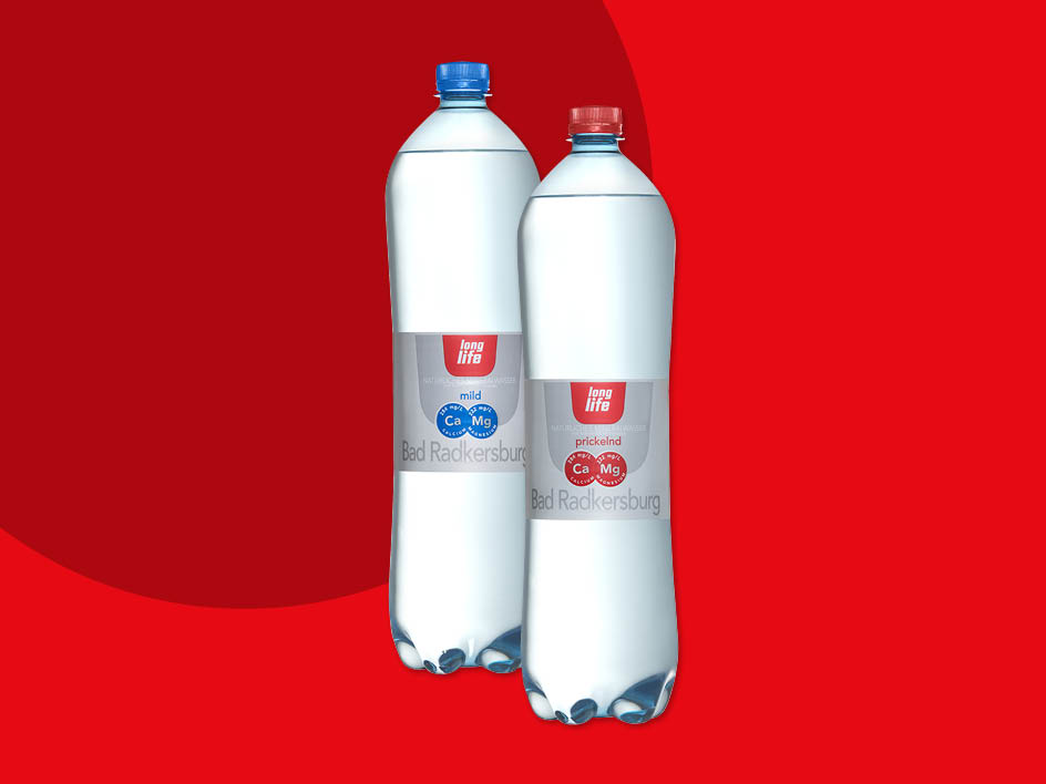 Zwei Flaschen Bad Radkersburg Mineralwasser, eine milde und eine prickelnde Sorte, auf rotem Hintergrund.