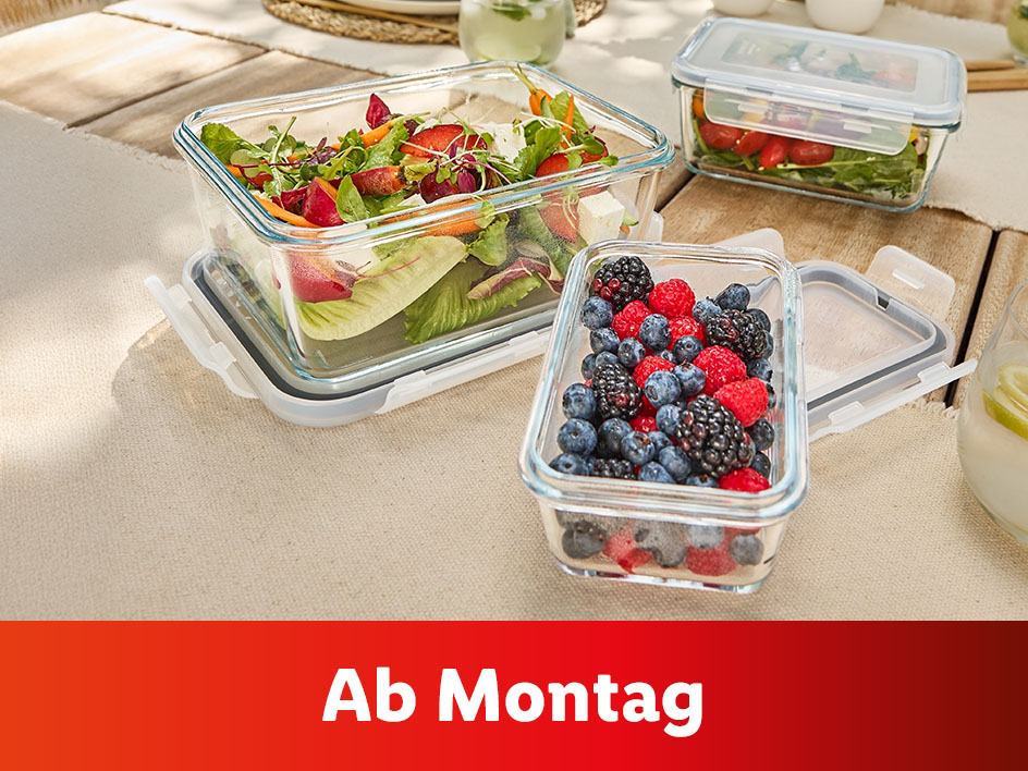 Glasbehälter mit Salat, Beeren und dem Text 'Ab Montag'.