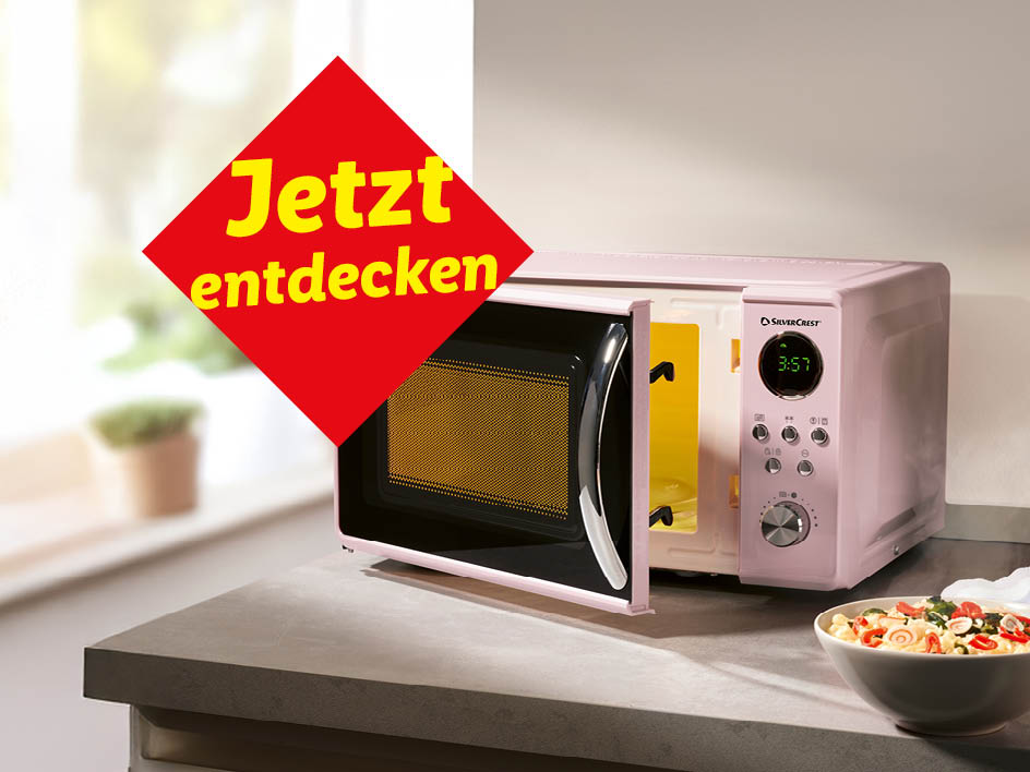 Ein rosafarbener SilverCrest Mikrowellenherd auf einer Küchenarbeitsplatte mit einer Schüssel Nudeln.