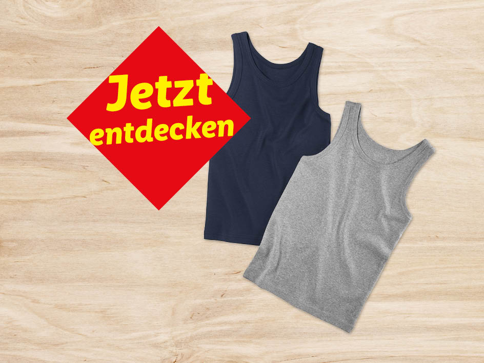Zwei Tanktops in dunkelblau und hellgrau liegen auf hellem Holz. Ein rotes Schild wirbt mit 'Jetzt entdecken'.