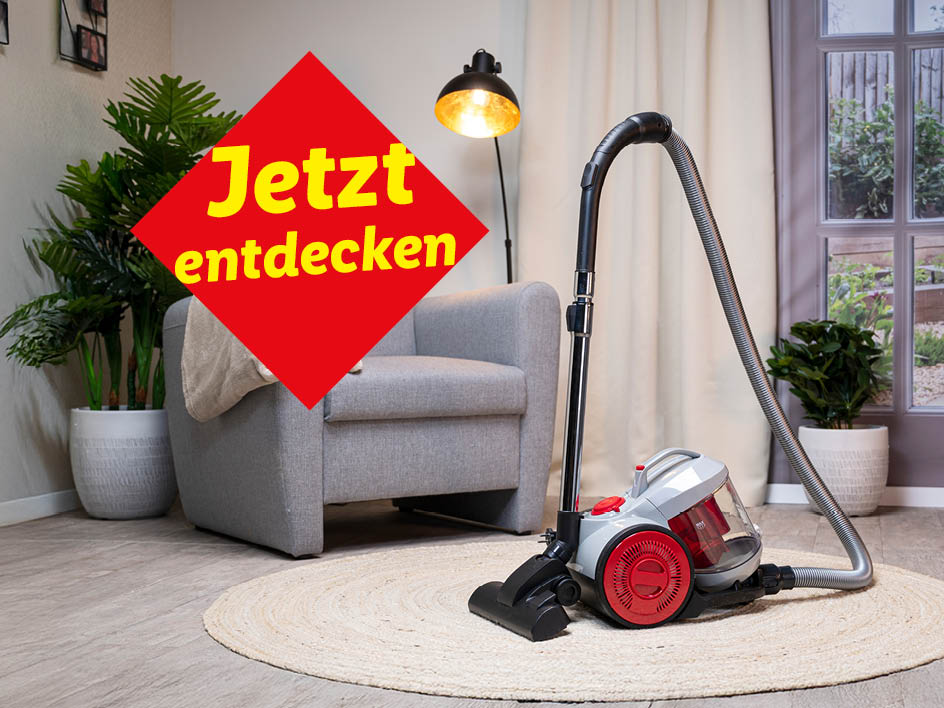 Ein neuer Staubsauger steht auf einem Teppich vor einem Sessel. Jetzt entdecken!