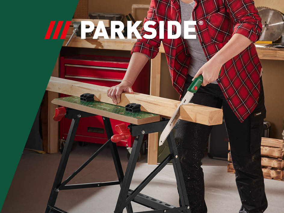 Eine Person verwendet eine Parkside-Handbügelsäge, um Holz auf einem Parkside-Werkbänken zu sägen.