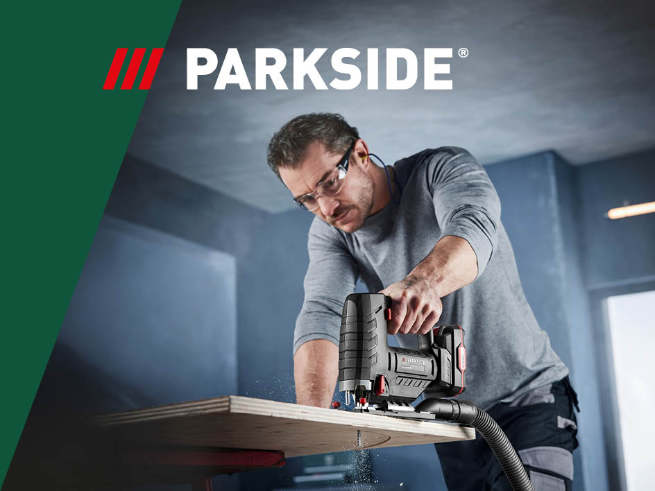 Ein Mann benutzt eine Parkside Stichsäge, um Holz zu schneiden.