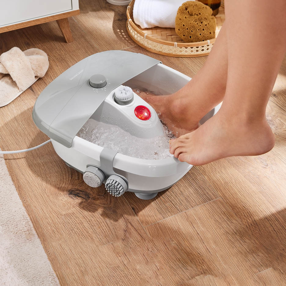 Eine Person genießt ein Fußbad in einem Fußsprudelbad mit Massagefunktion.