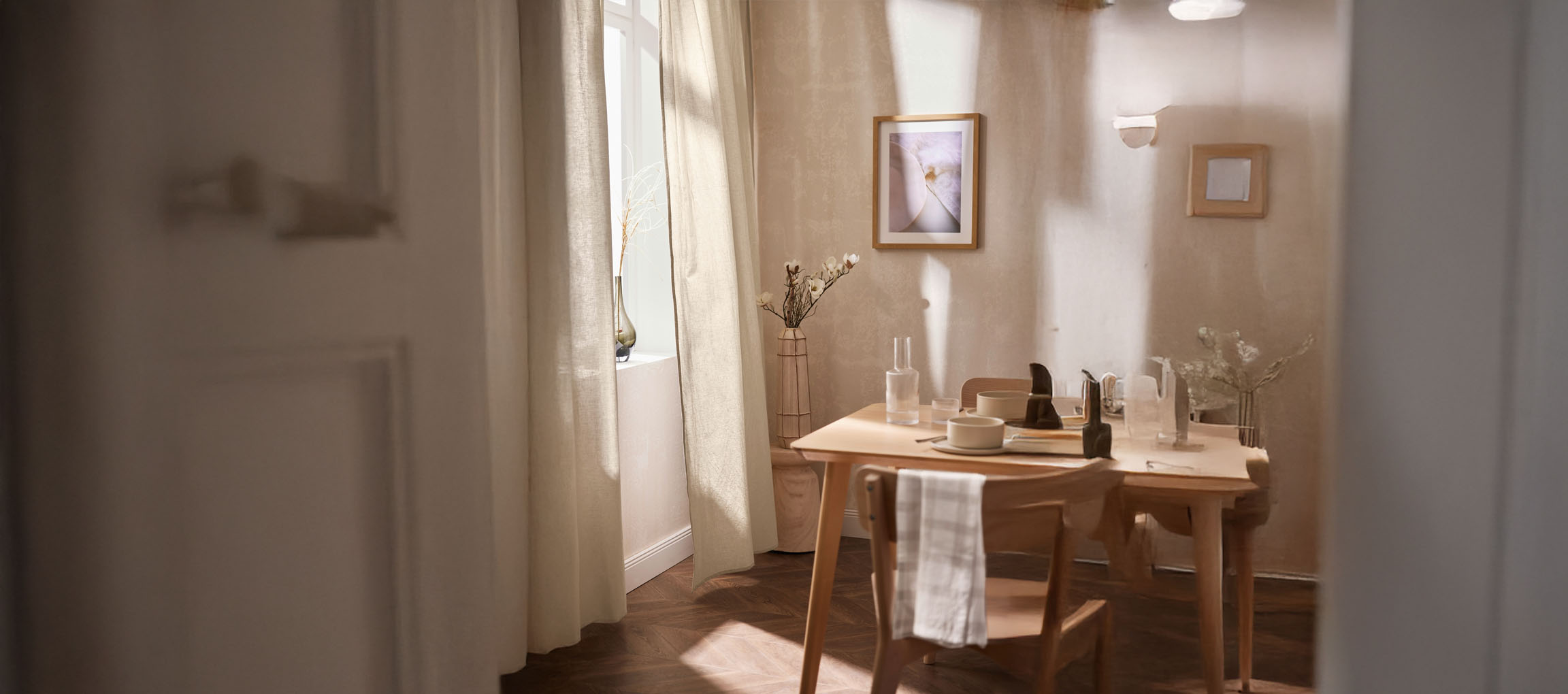 Helles Esszimmer mit Holztisch, Stühlen und minimalistischen Dekorationen.