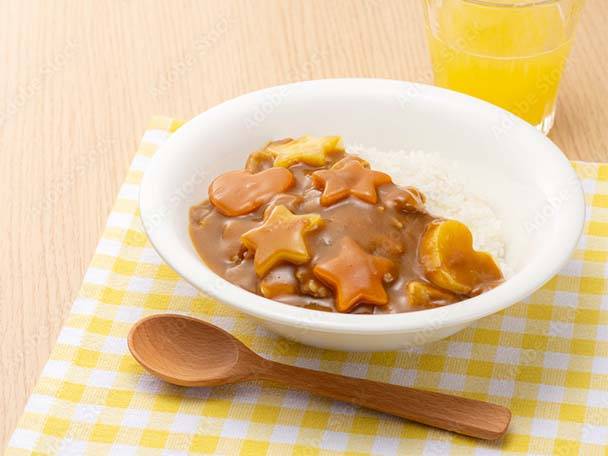 Curryreis mit stern- und herzförmigen Karotten, dazu Orangensaft.