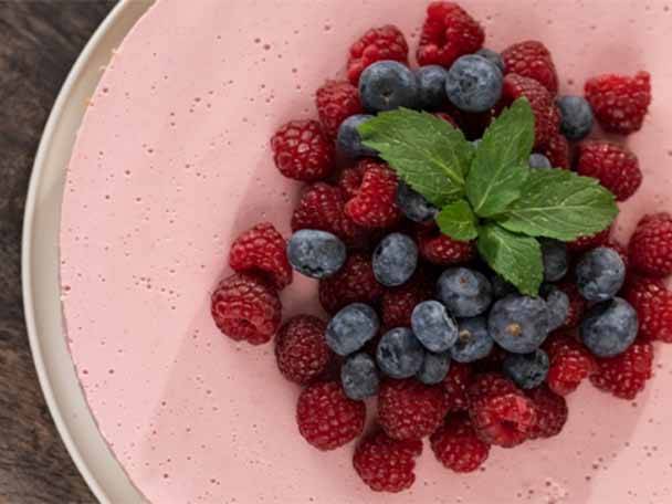 Rosa Kuchen mit Himbeeren, Blaubeeren und Minze.